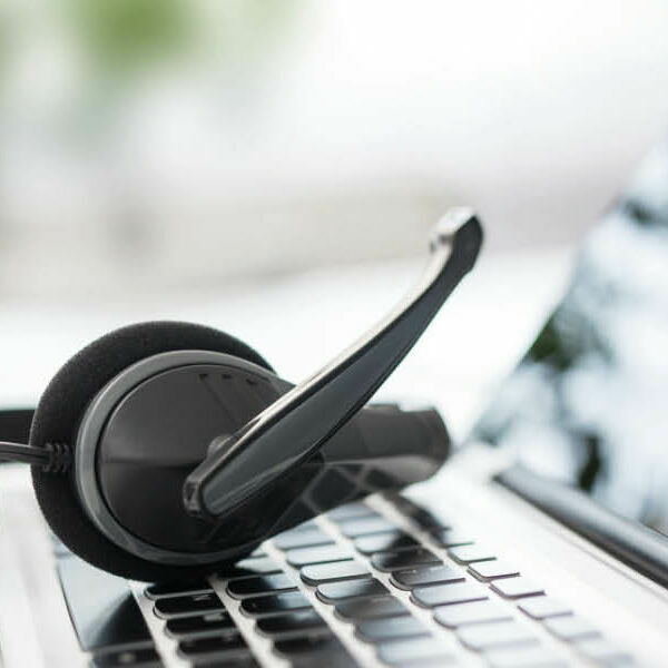 Ein Headset liegt auf der Tastatur eines Laptops